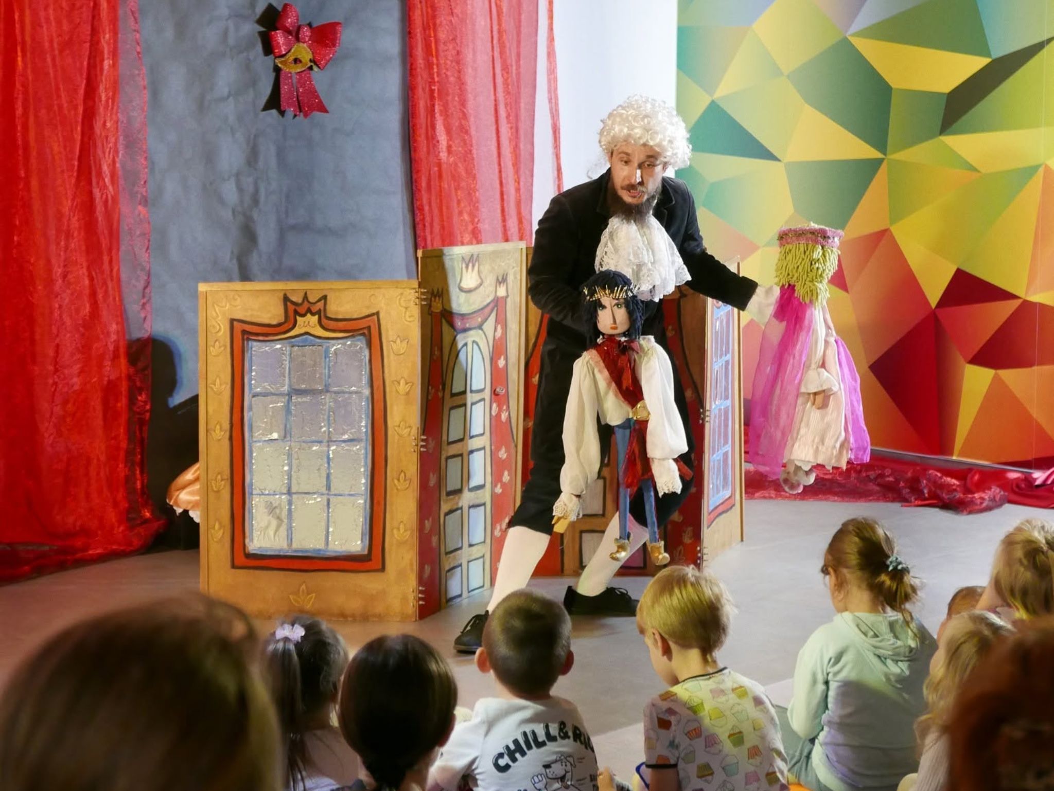 Zdjęcie aktora z lalką księcia oraz widzów.