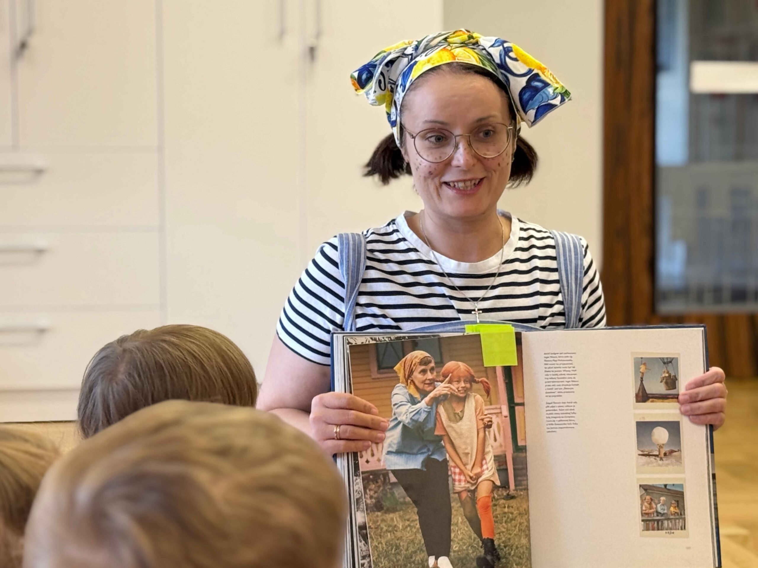Zdjęcie prowadzącej z książką, w której zamieszczono zdjęcie Astrid Lindgren podczas kręcenia filmu o Pippi Pończoszance.